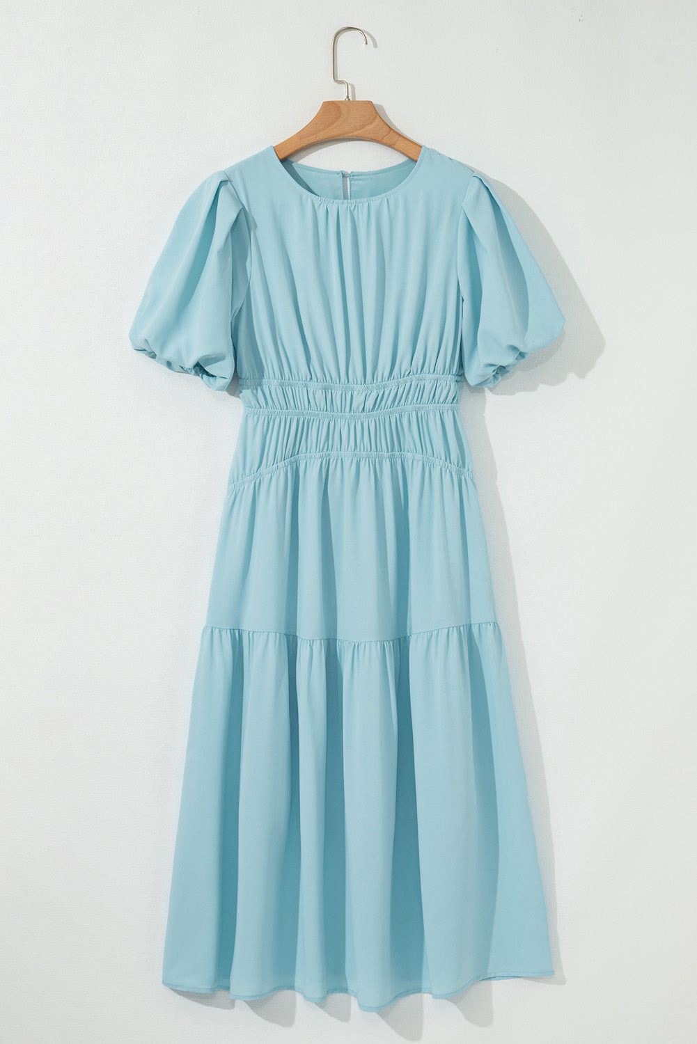 Light blue dress on a hanger against a white background