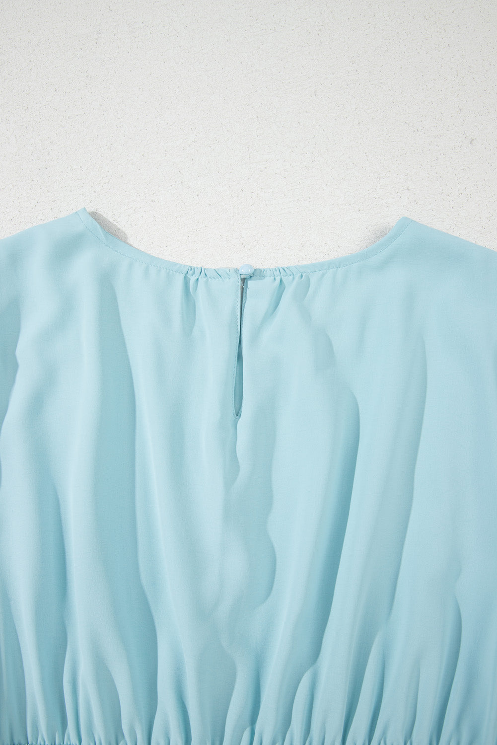 Light blue fabric on a textured white background