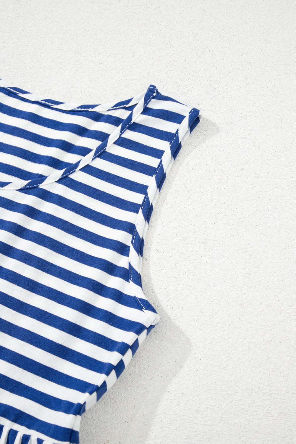 Blue and white striped fabric on a light gray background