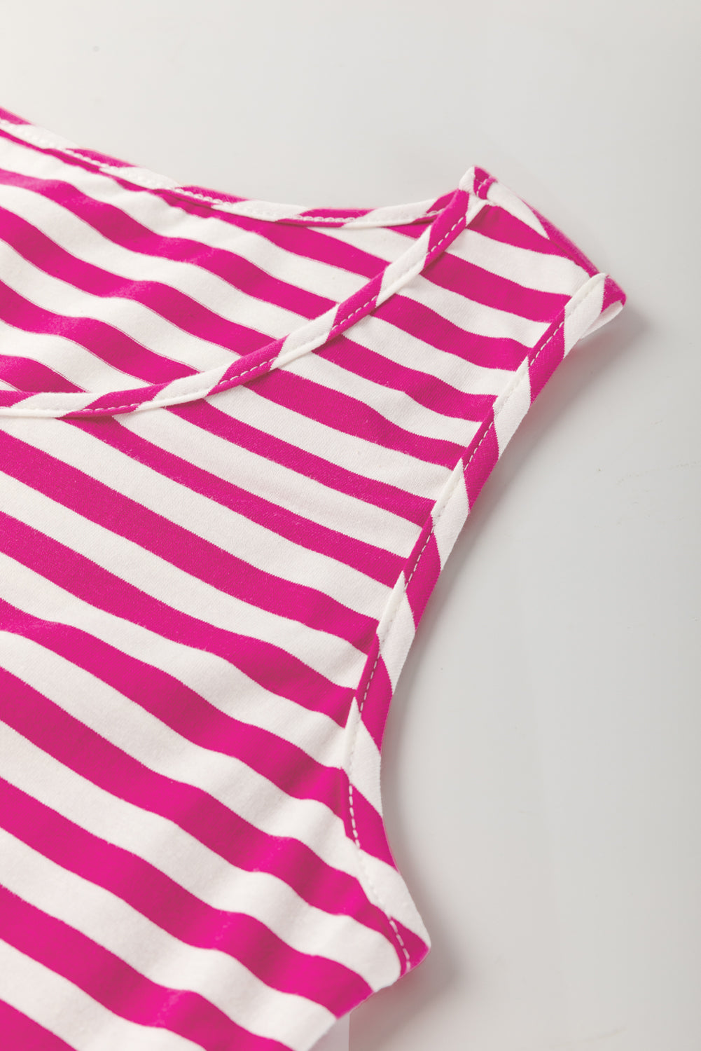 Pink and white striped fabric on a light gray background
