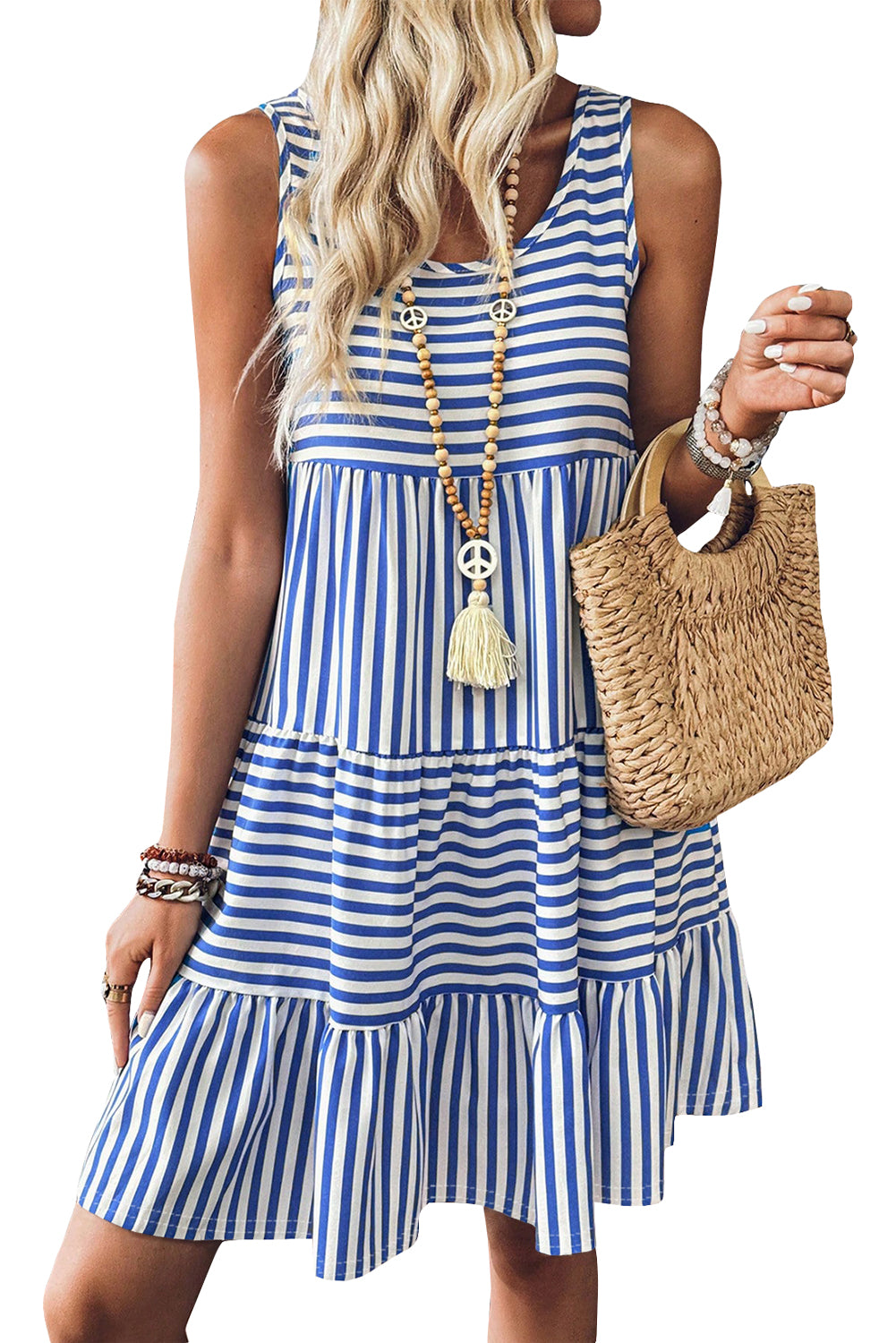 Woman wearing a blue and white striped dress holding a woven bag.