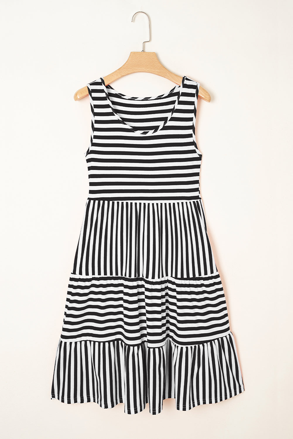 Black and white striped dress on a hanger against a white background