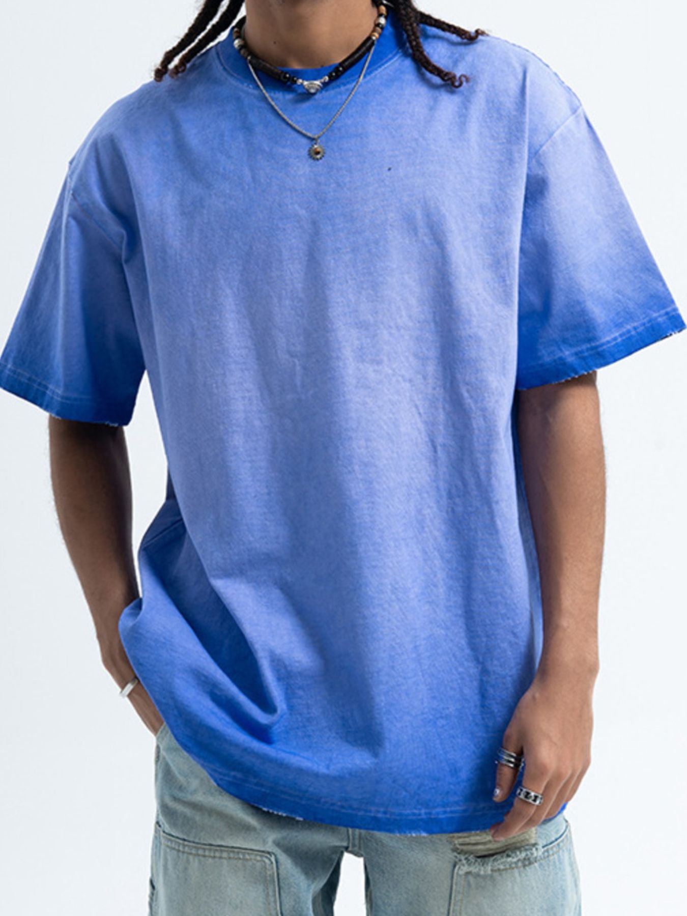 Person wearing a blue t-shirt on a plain background