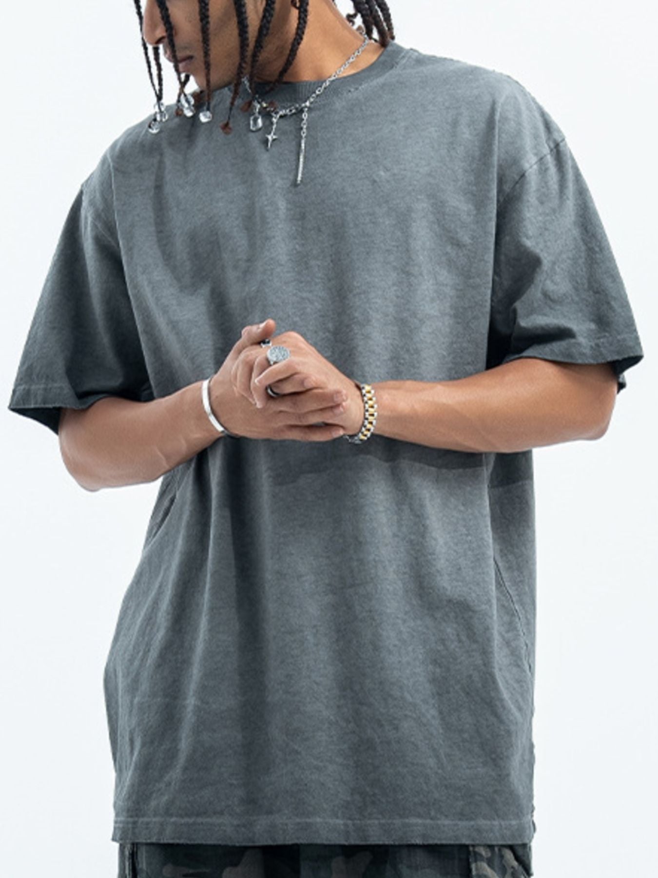 Person wearing a plain gray t-shirt on a white background