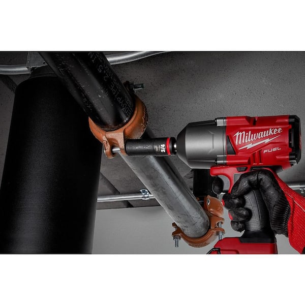 Person using a Milwaukee power tool on a pipe